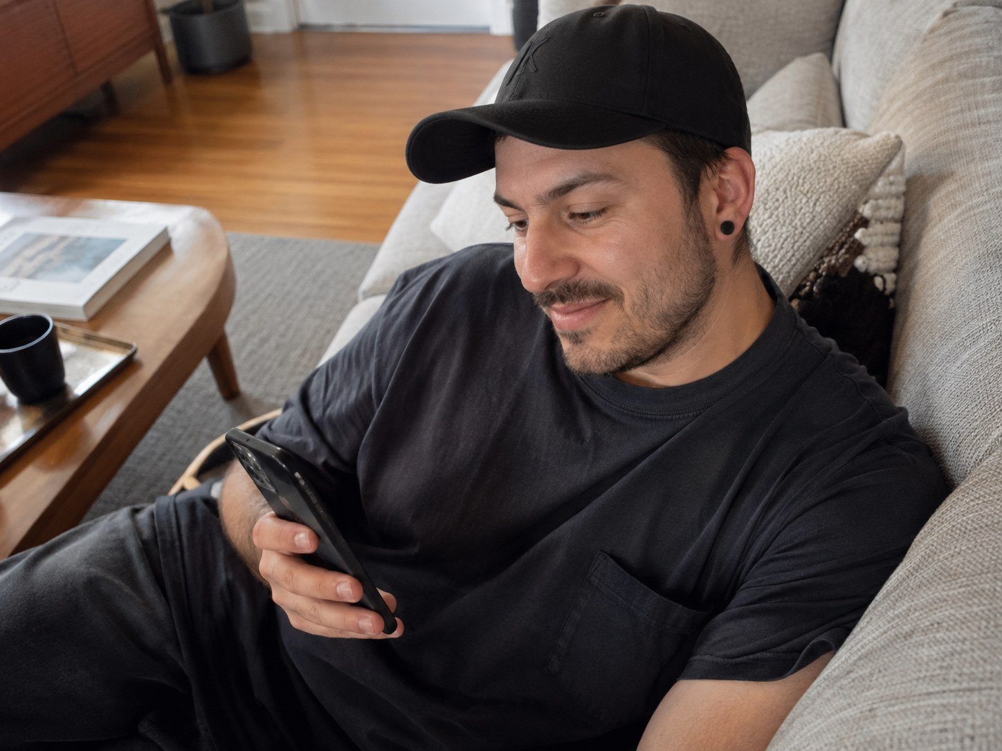 A man relaxing on a sofa while using a phone at home